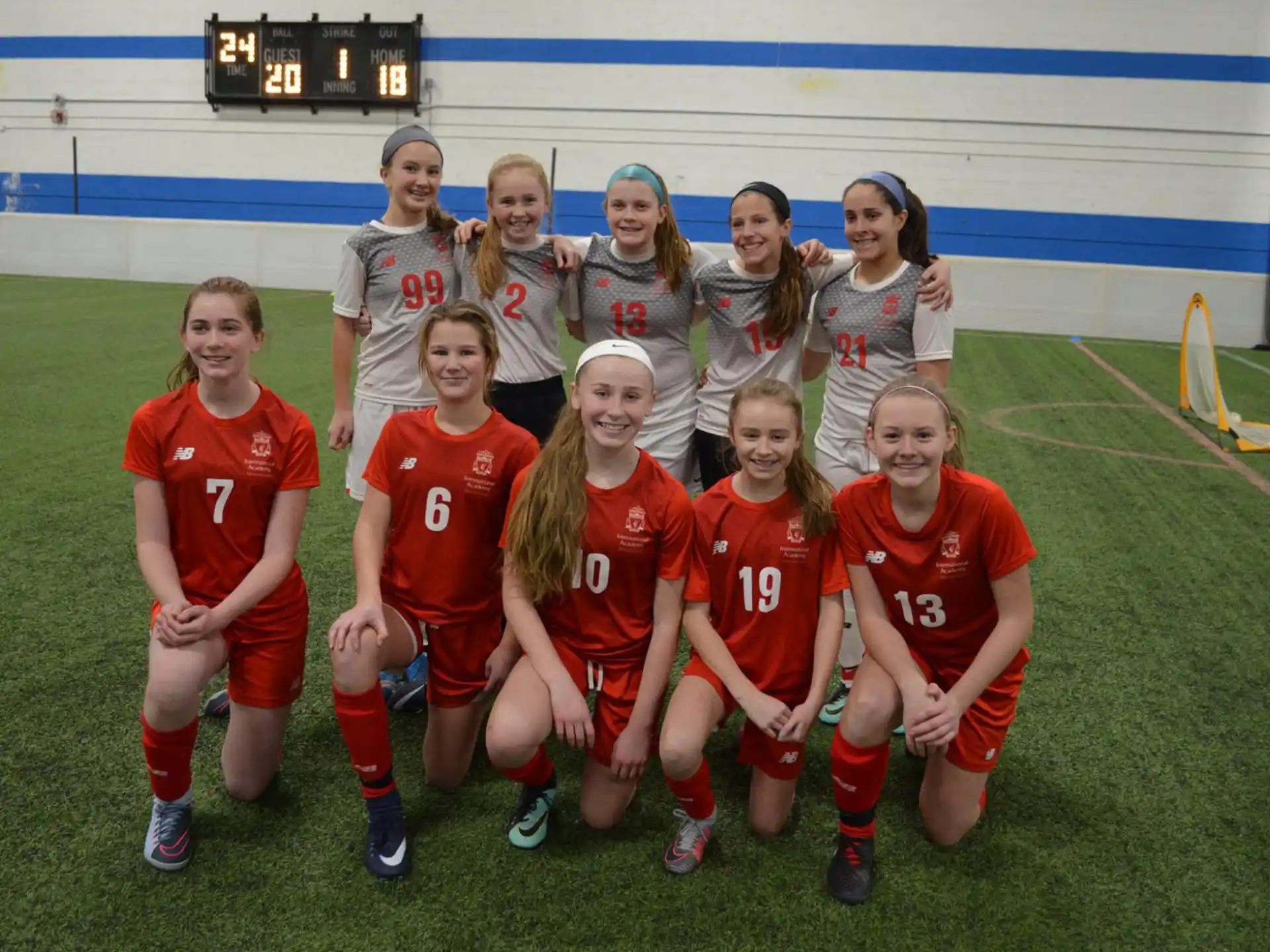 a group of girls posing for a picture on a football field