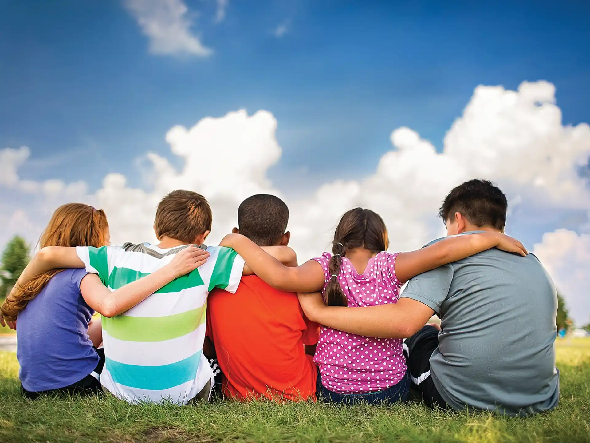 a group of people sitting on grass