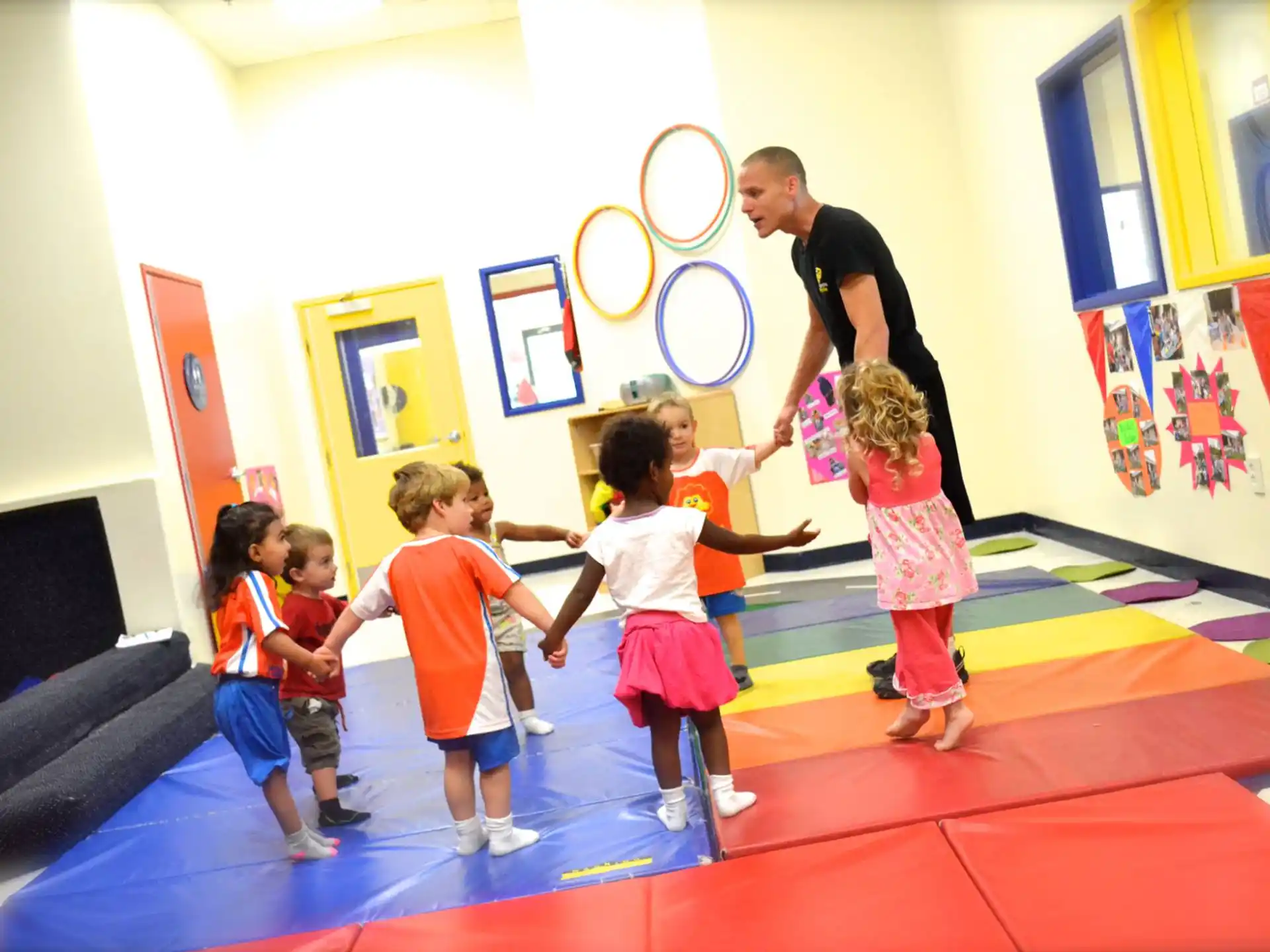 a person and a group of children in a room with a red carpet