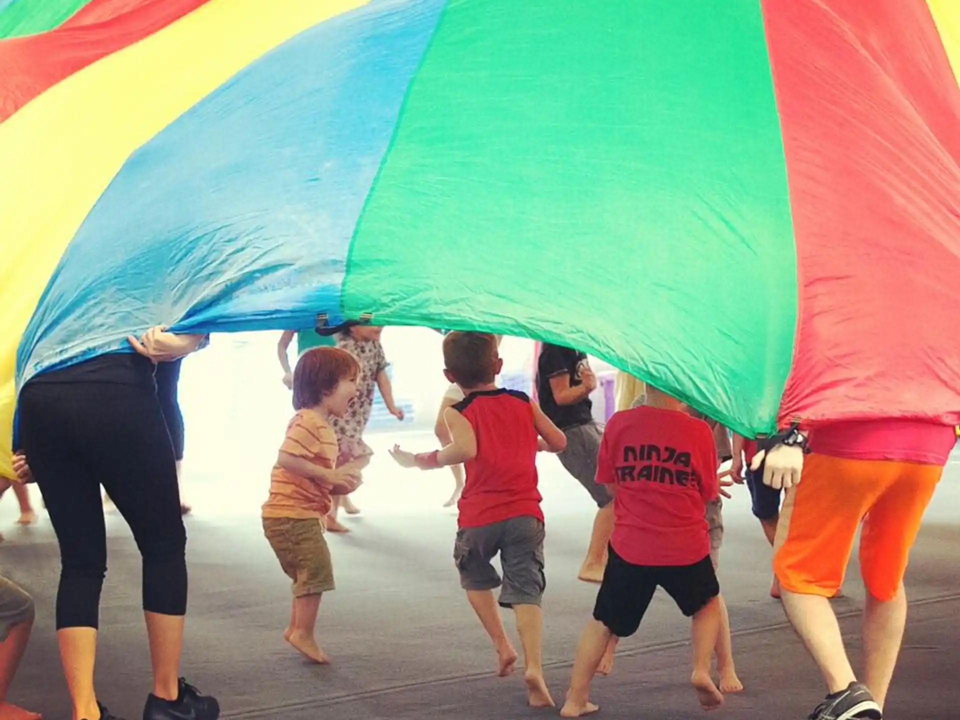 a group of people holding a rainbow colored umbrella