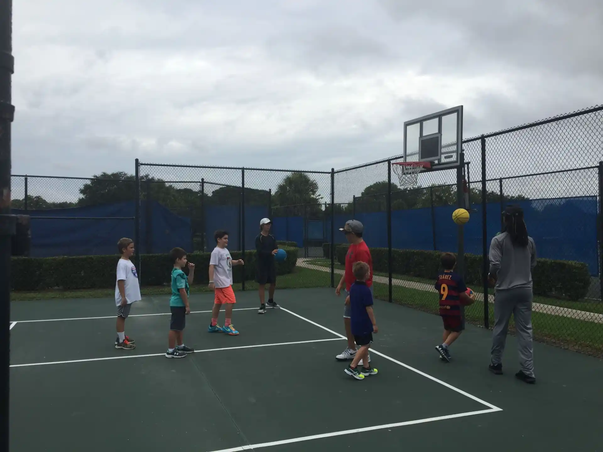 a group of kids playing tennis