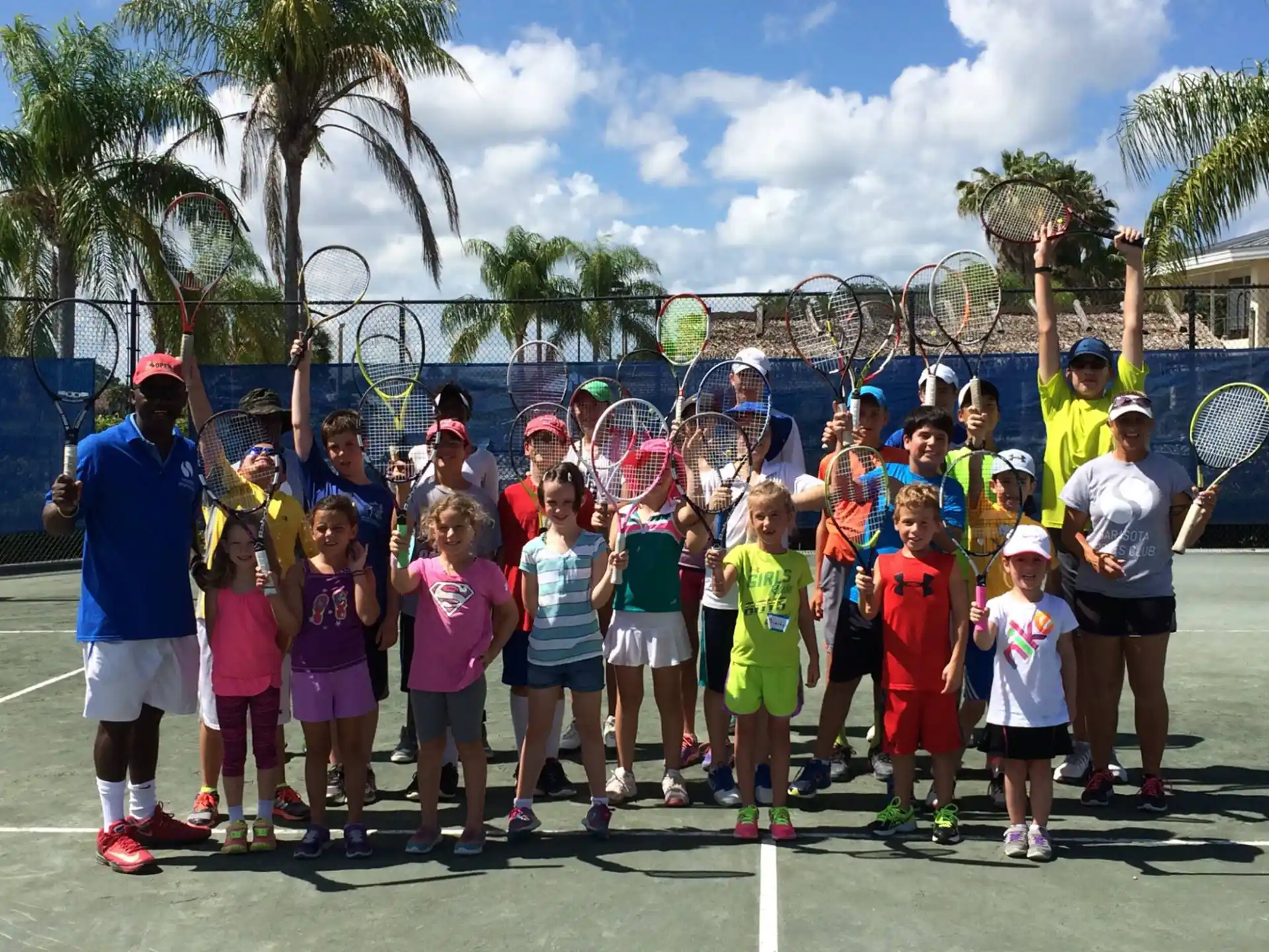 a group of people posing for a photo with tennis rackets