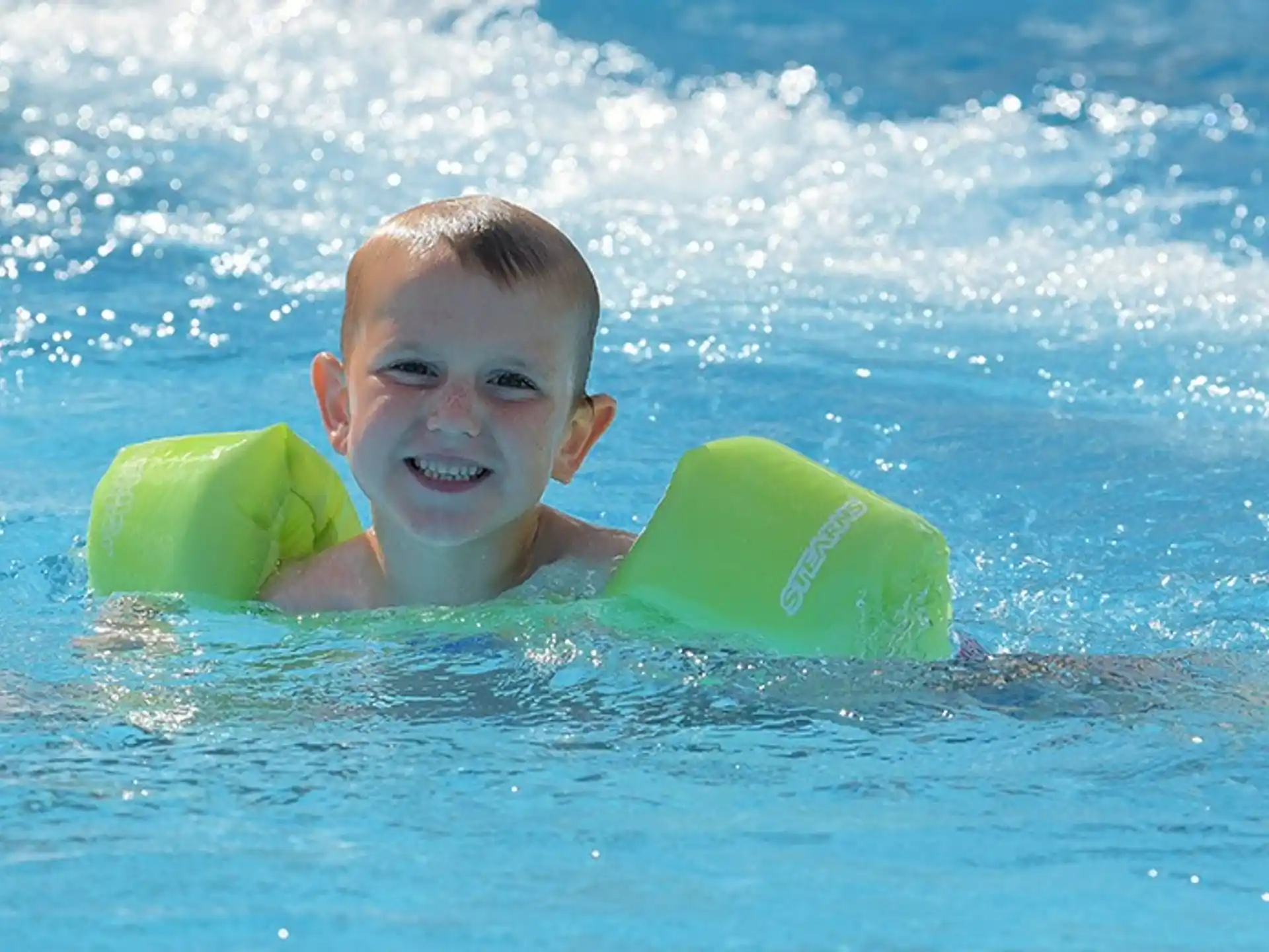 a boy in the water with a surfboard