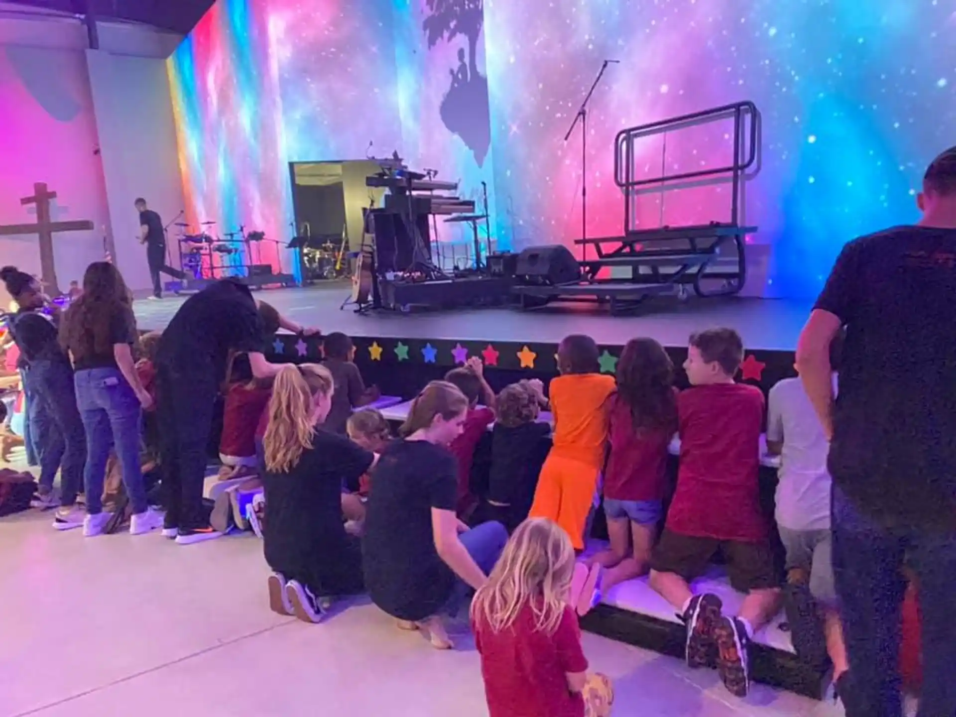 a group of people sitting on the floor in front of a stage