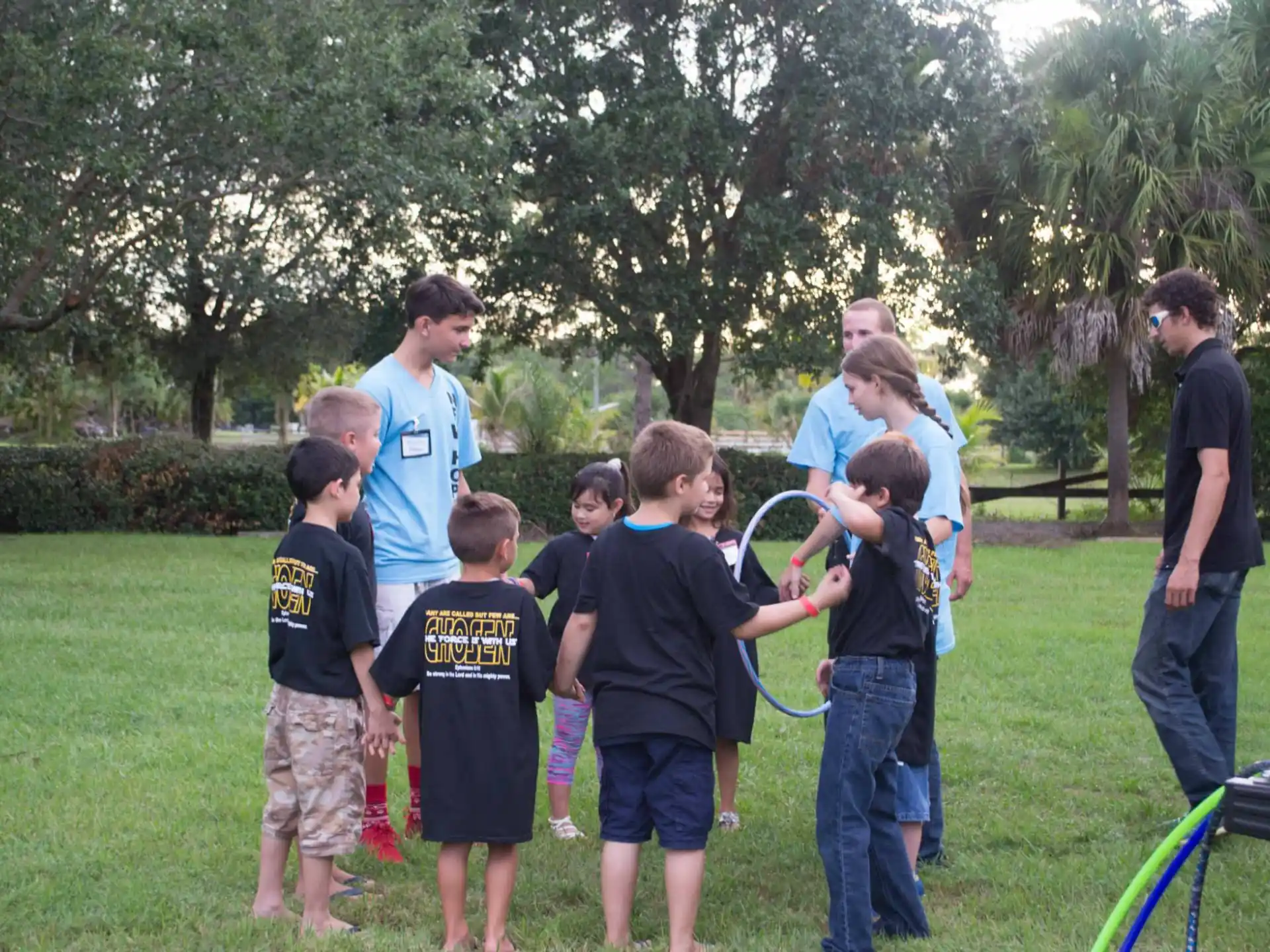 a group of people standing in a grassy area