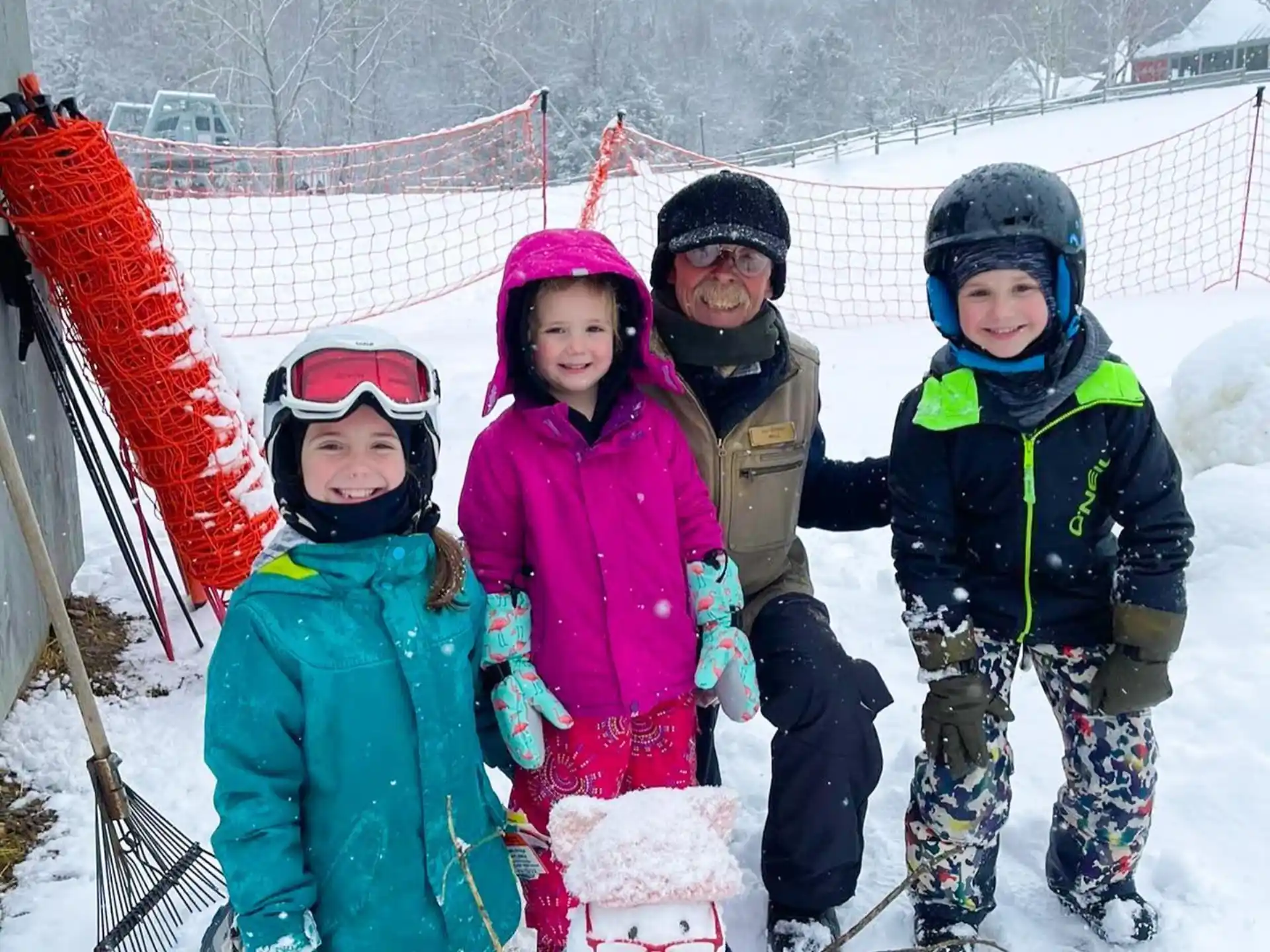 a group of kids posing for a picture with a snowman