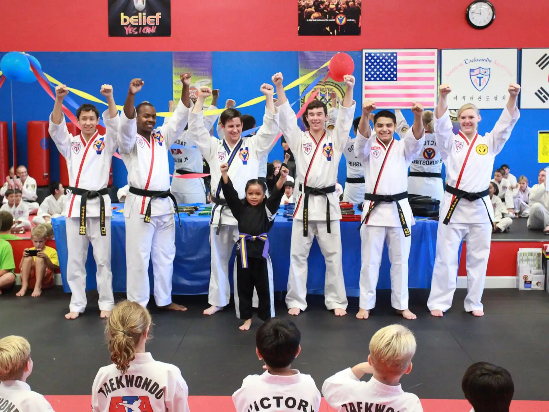 a group of people in white karate uniforms on a stage