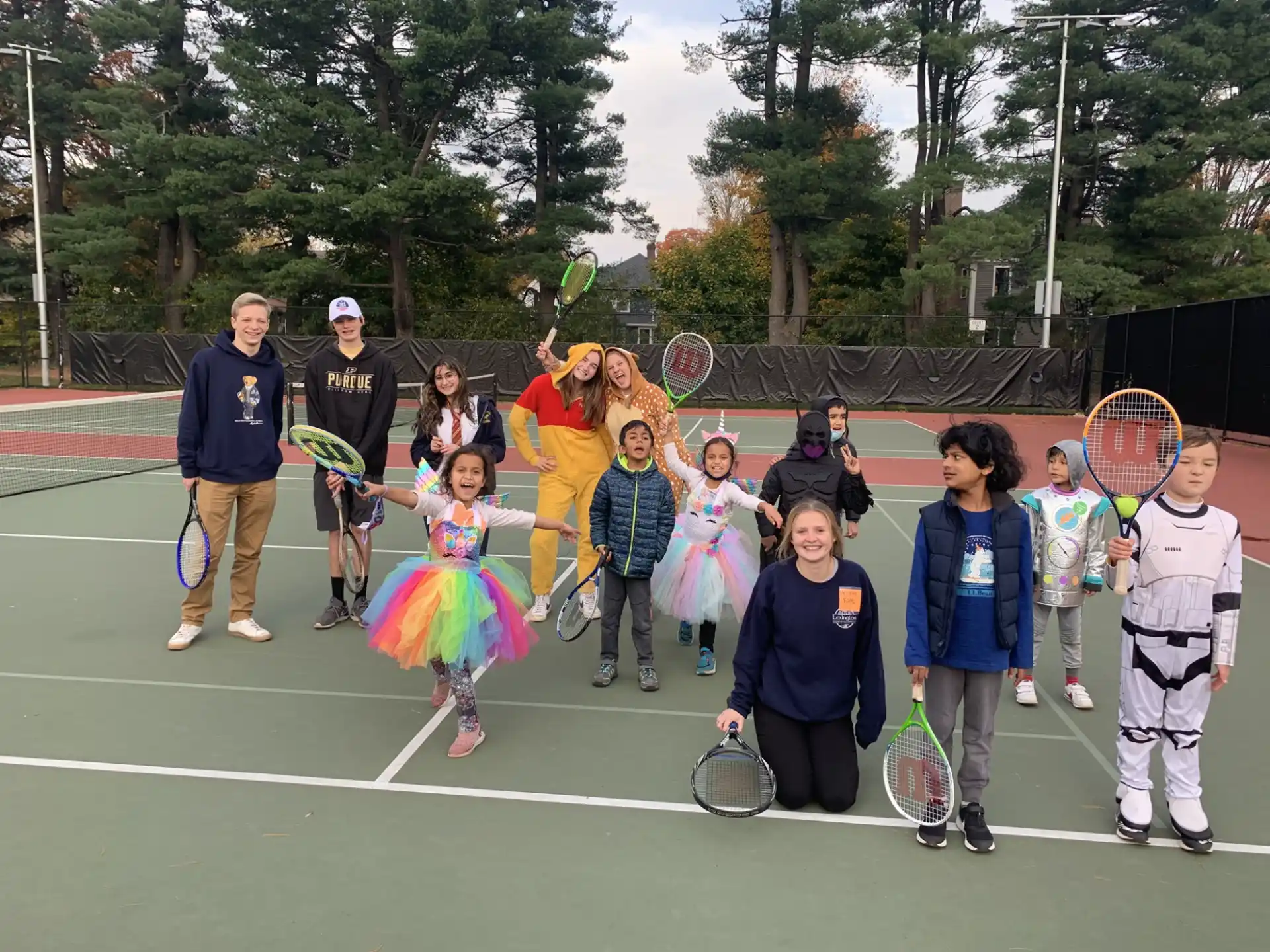 a group of people holding tennis rackets on a tennis court