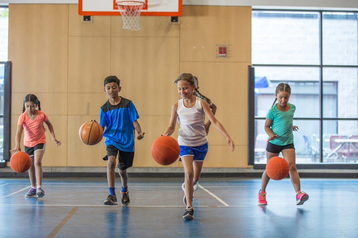 a group of kids playing basketball