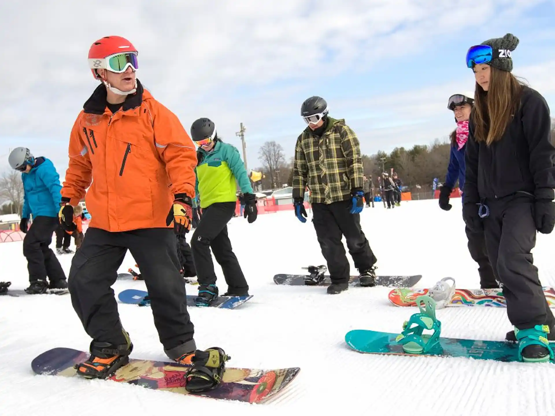 a group of people stand around snowboards
