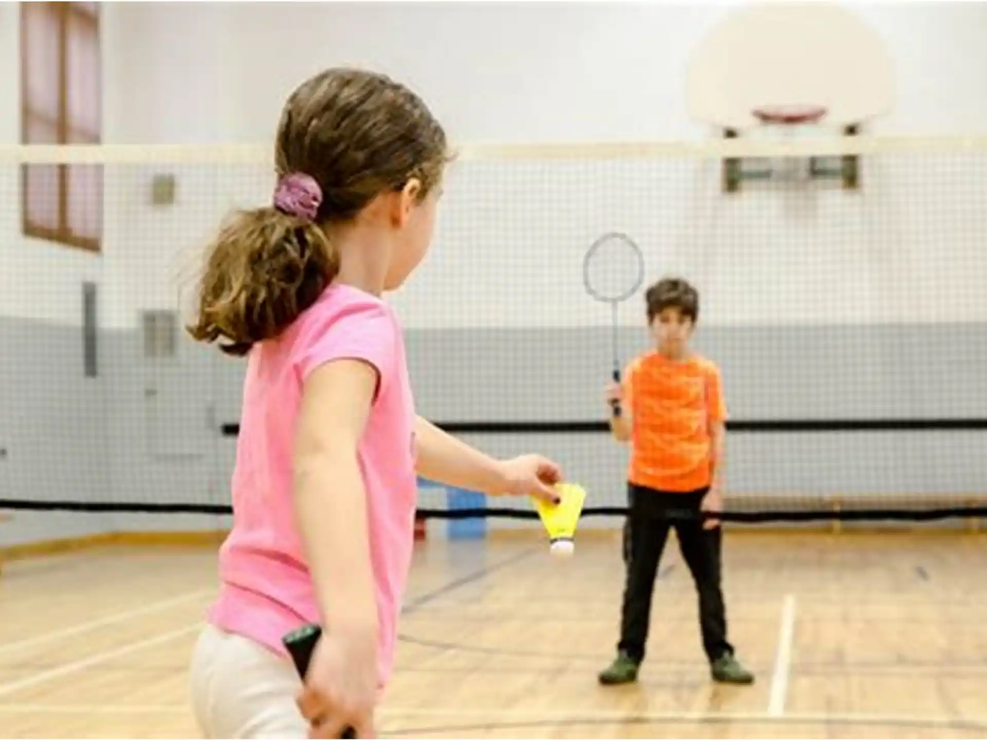 a couple of children playing tennis