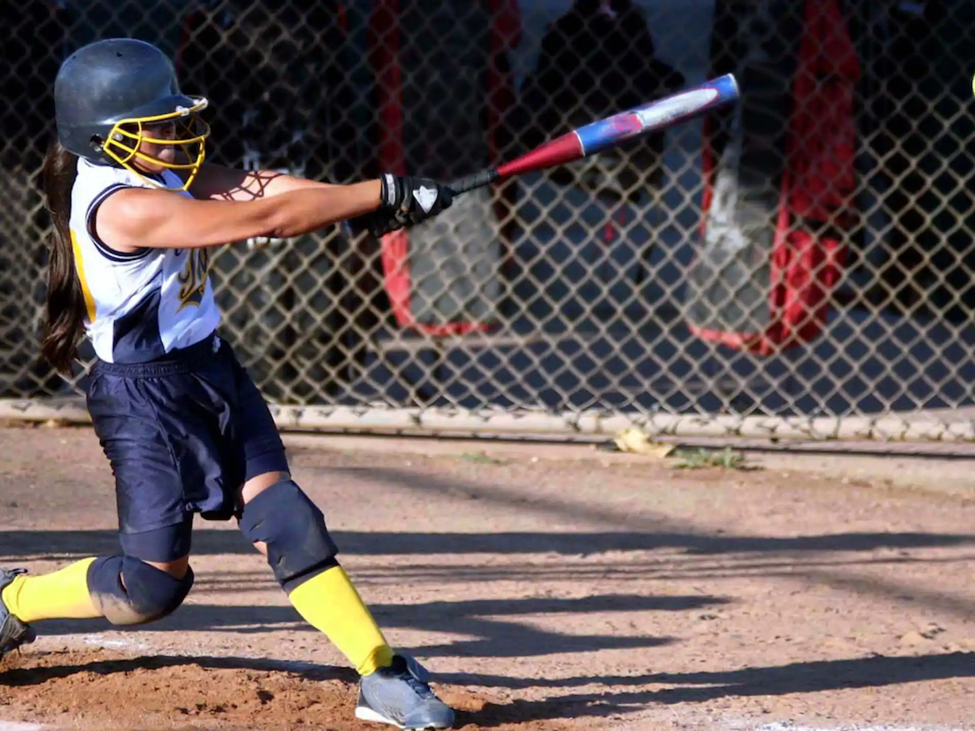 a girl swinging a baseball bat