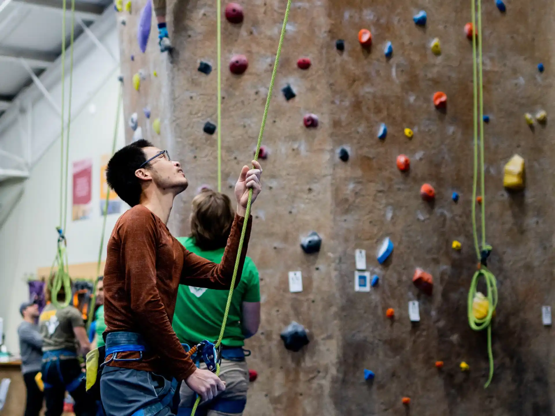 a man and woman climbing a rock wall