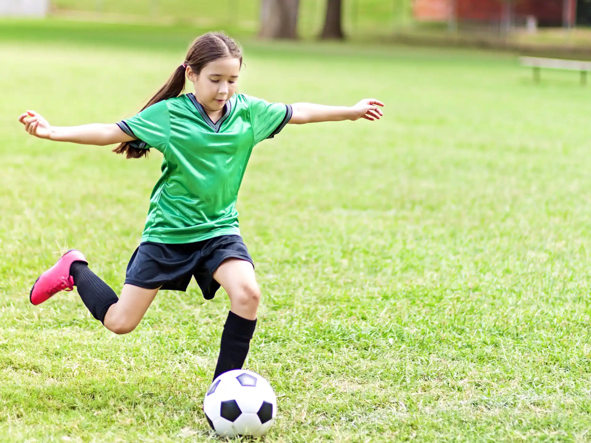 a girl kicking a football ball