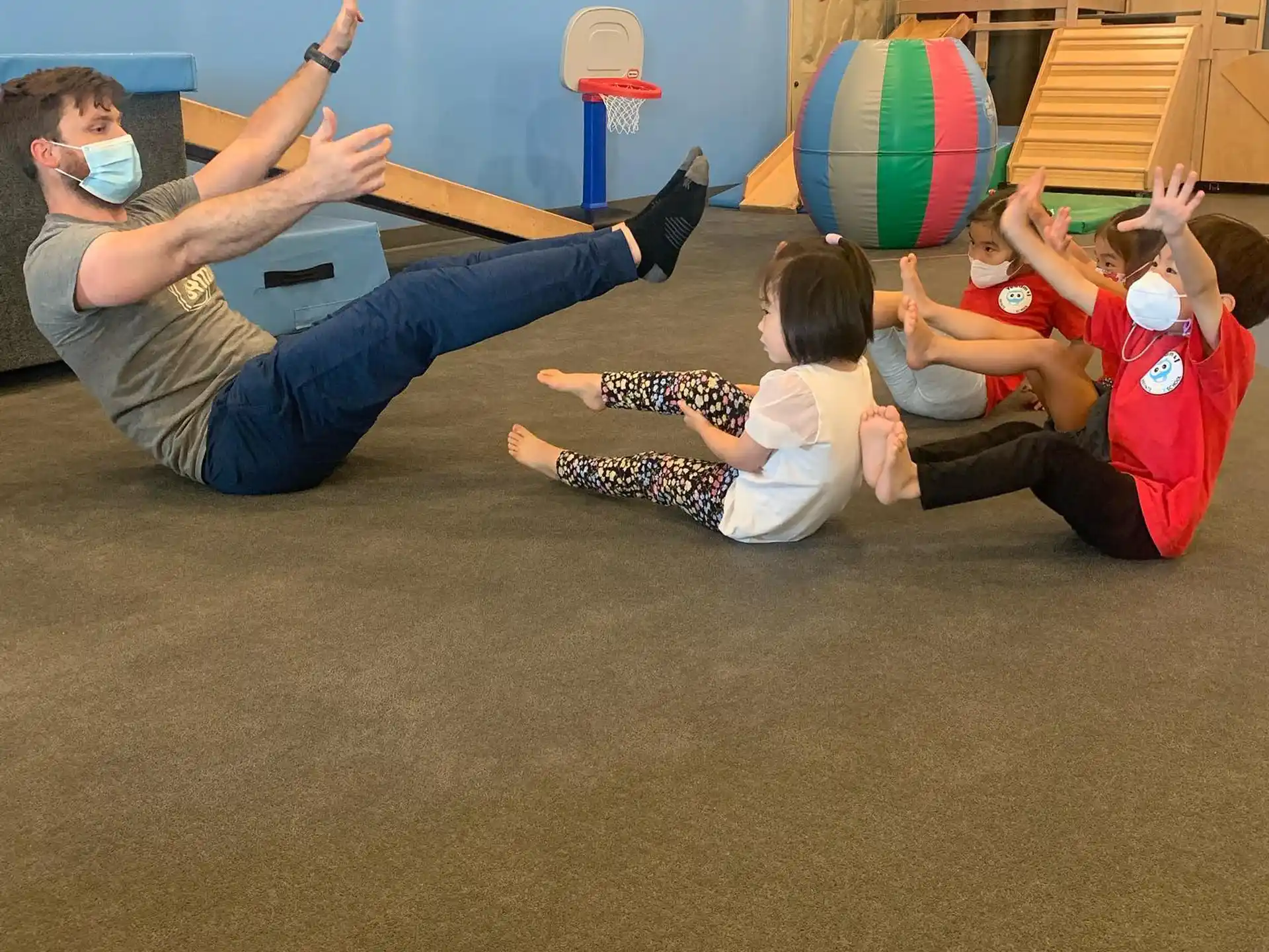 a group of people sitting on the floor with a ball