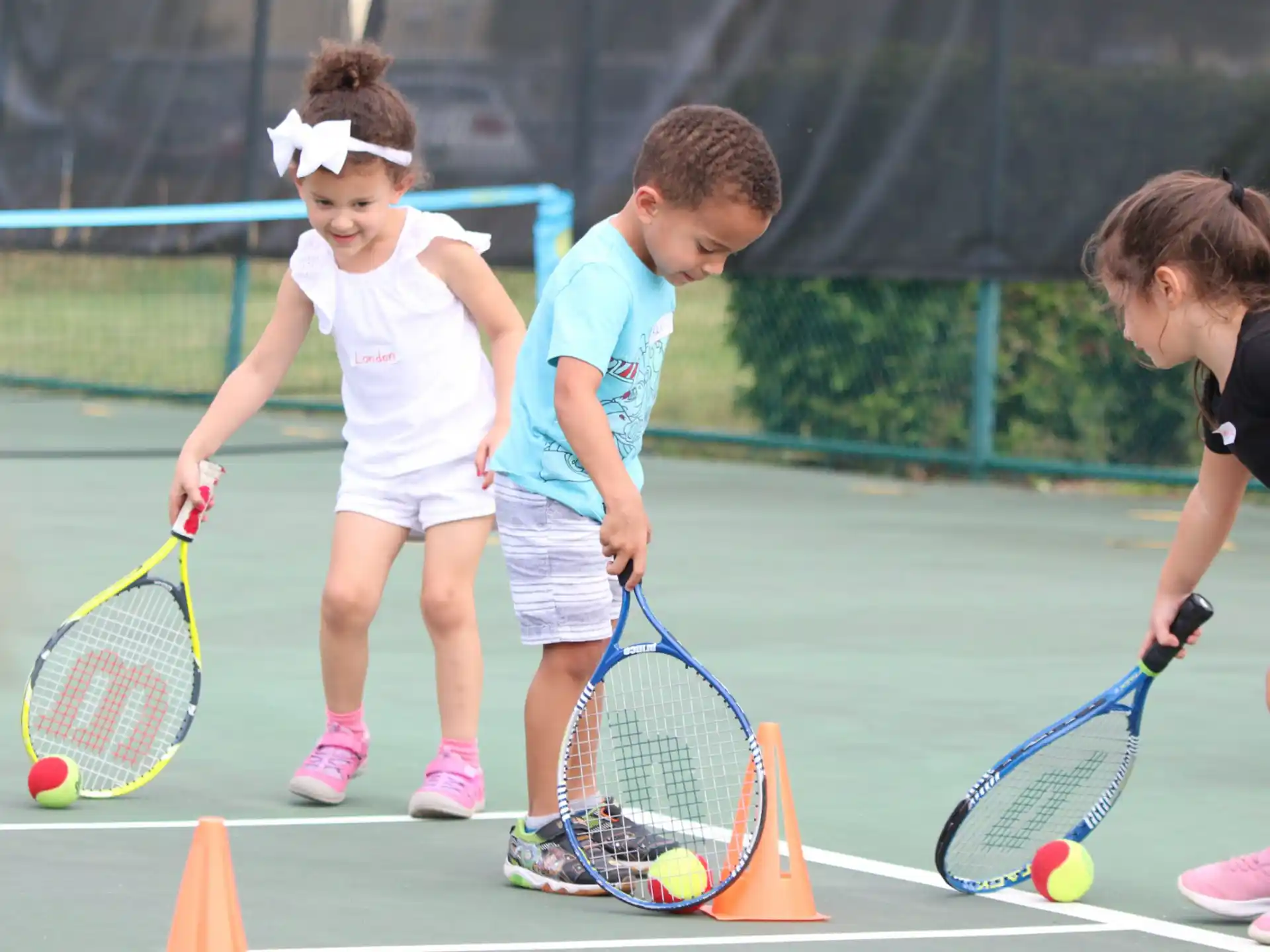 kids playing tennis on a court