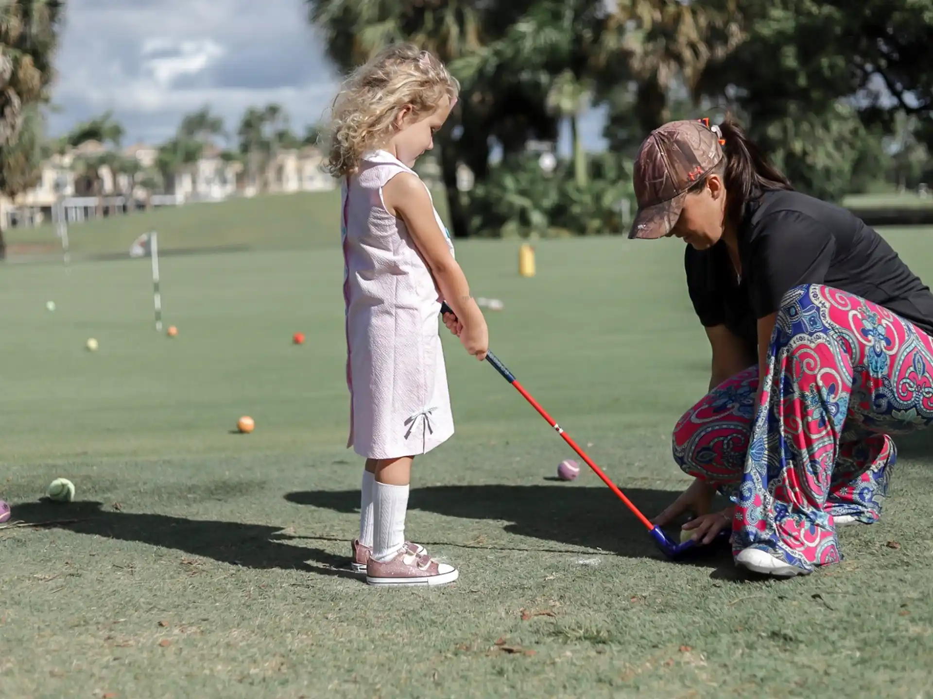 a person and a girl playing golf