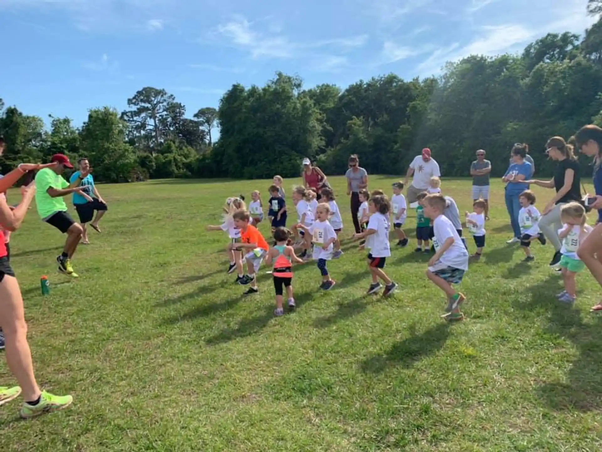 a group of people running on a grass field