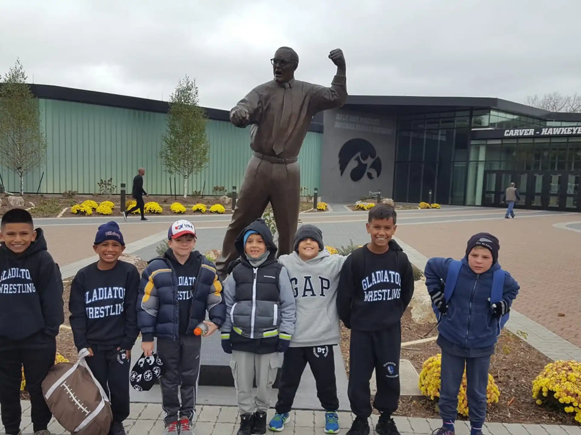 a group of people posing for a photo in front of a statue