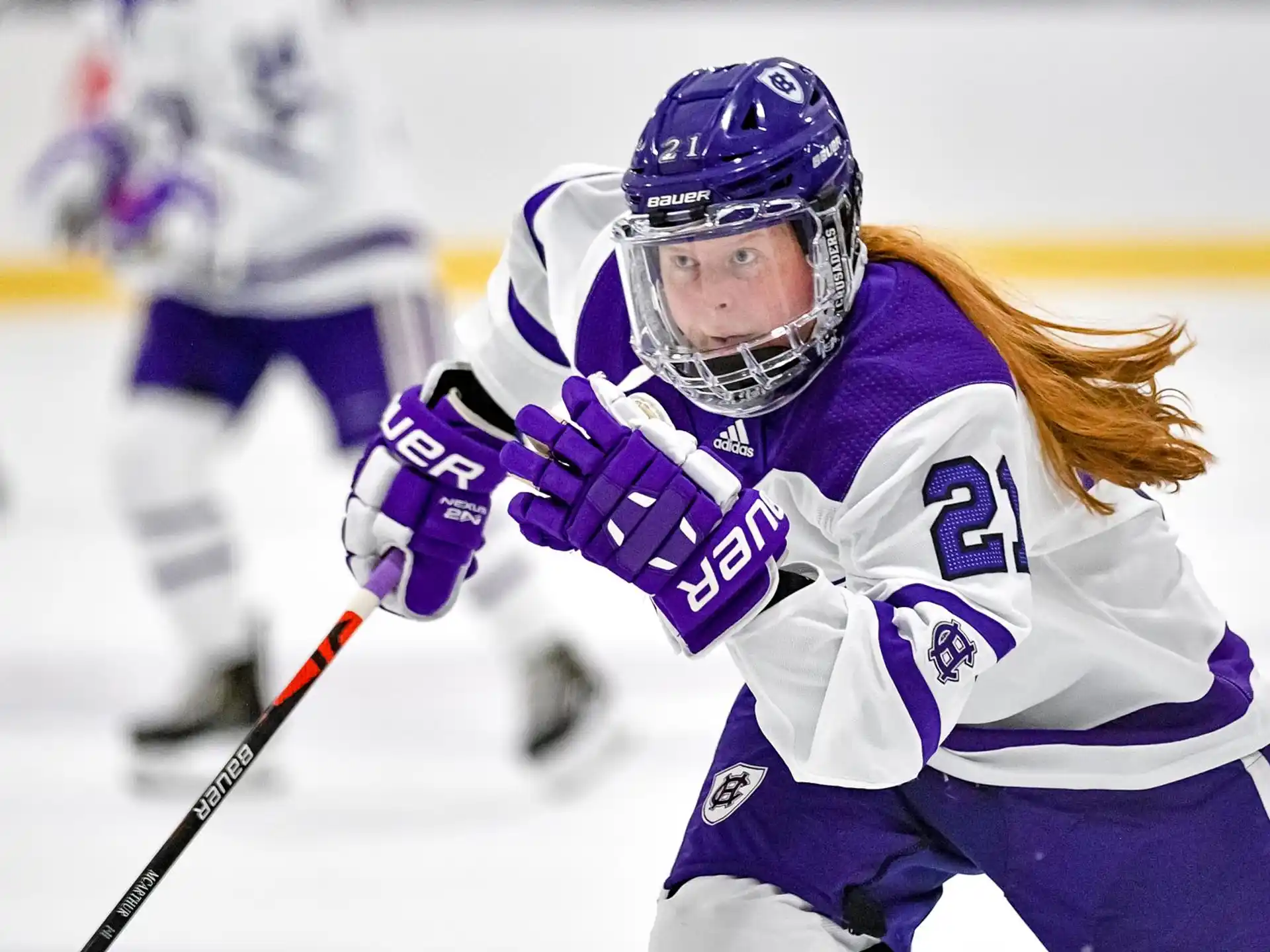 a person wearing a hockey uniform and helmet on ice