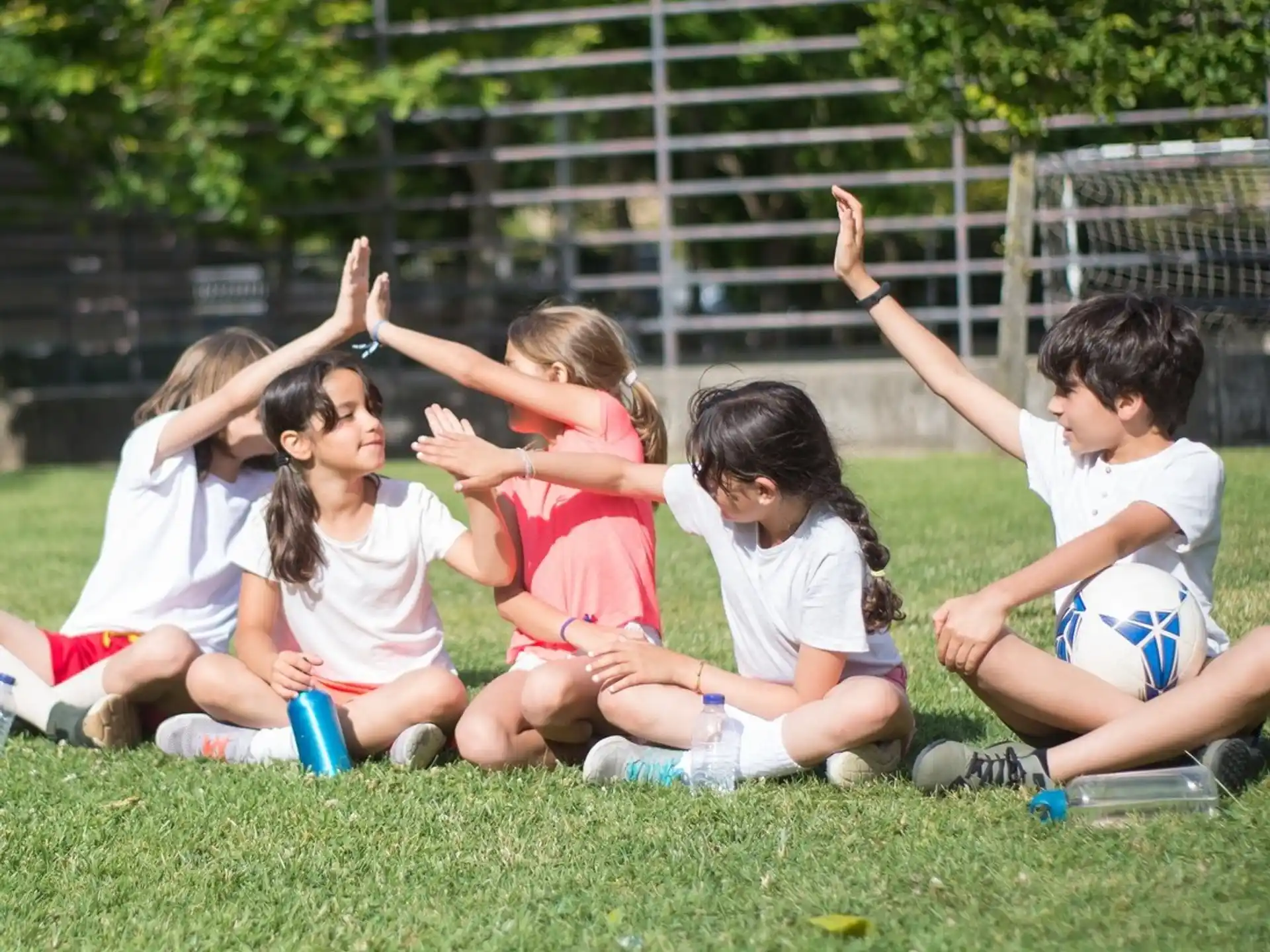 a group of children sitting on the grass