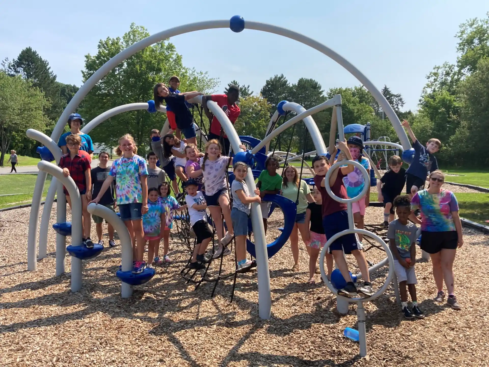 a group of people posing for a photo in front of a playground