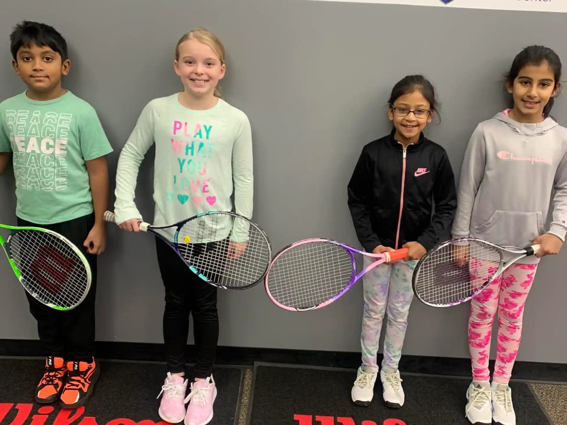 a group of girls holding tennis rackets