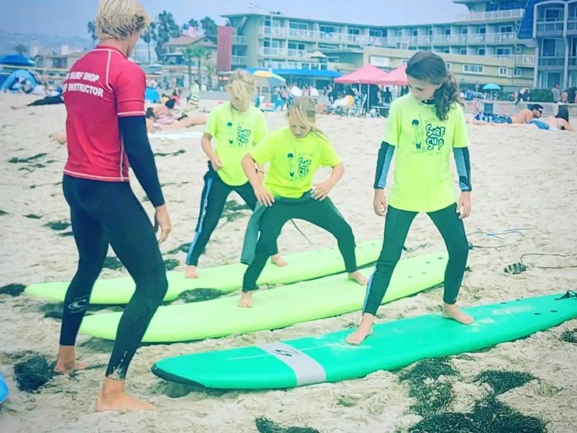 a group of people stand on surfboards on a beach