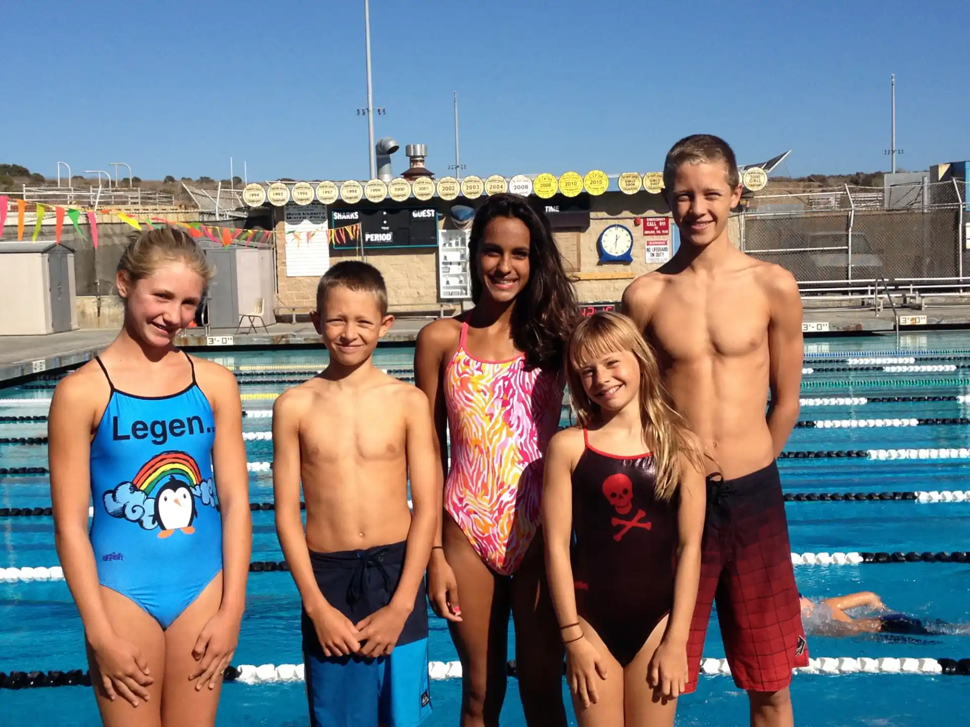 a group of people posing for a photo in front of a pool