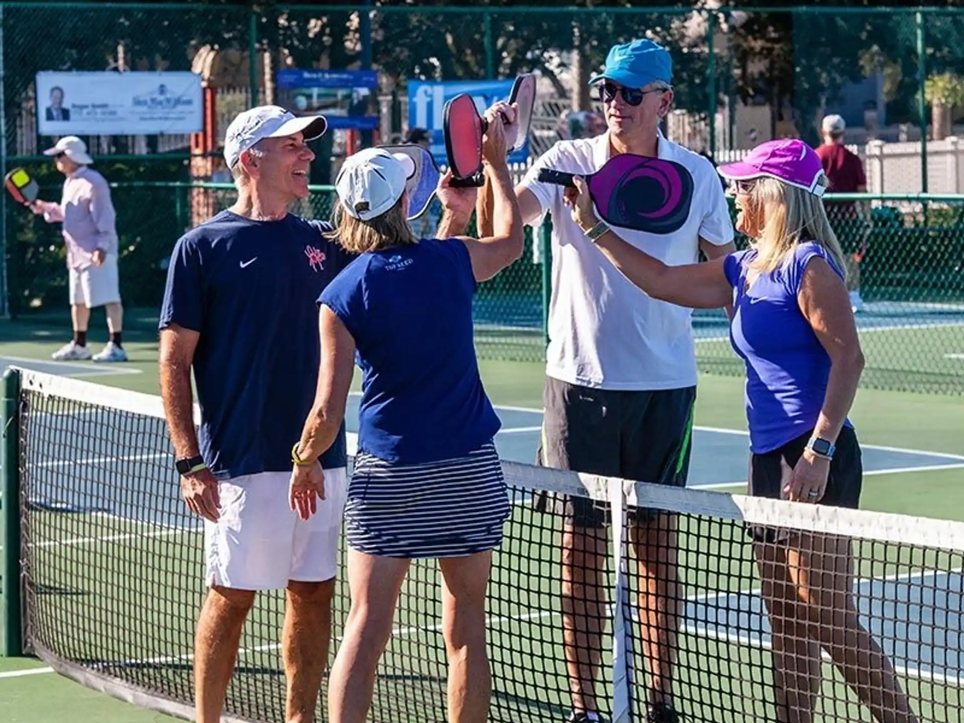 a group of people stand on a tennis court