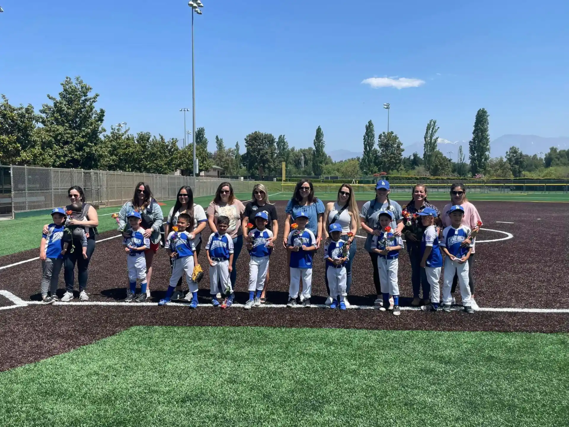 a group of people posing for a photo on a baseball field