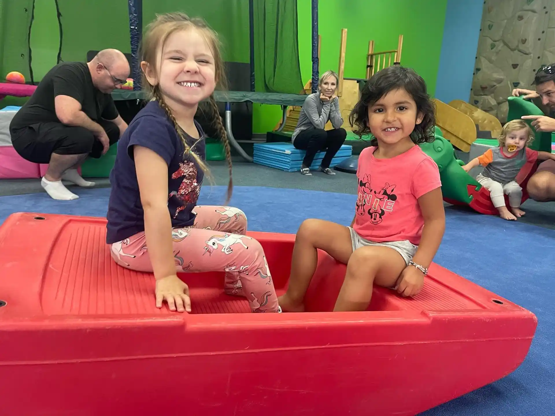 a group of children sitting on a red and yellow slide