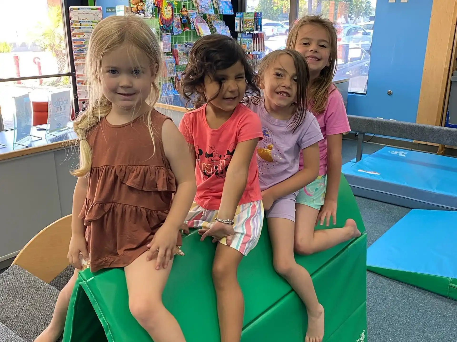 a group of girls sitting on a green bench
