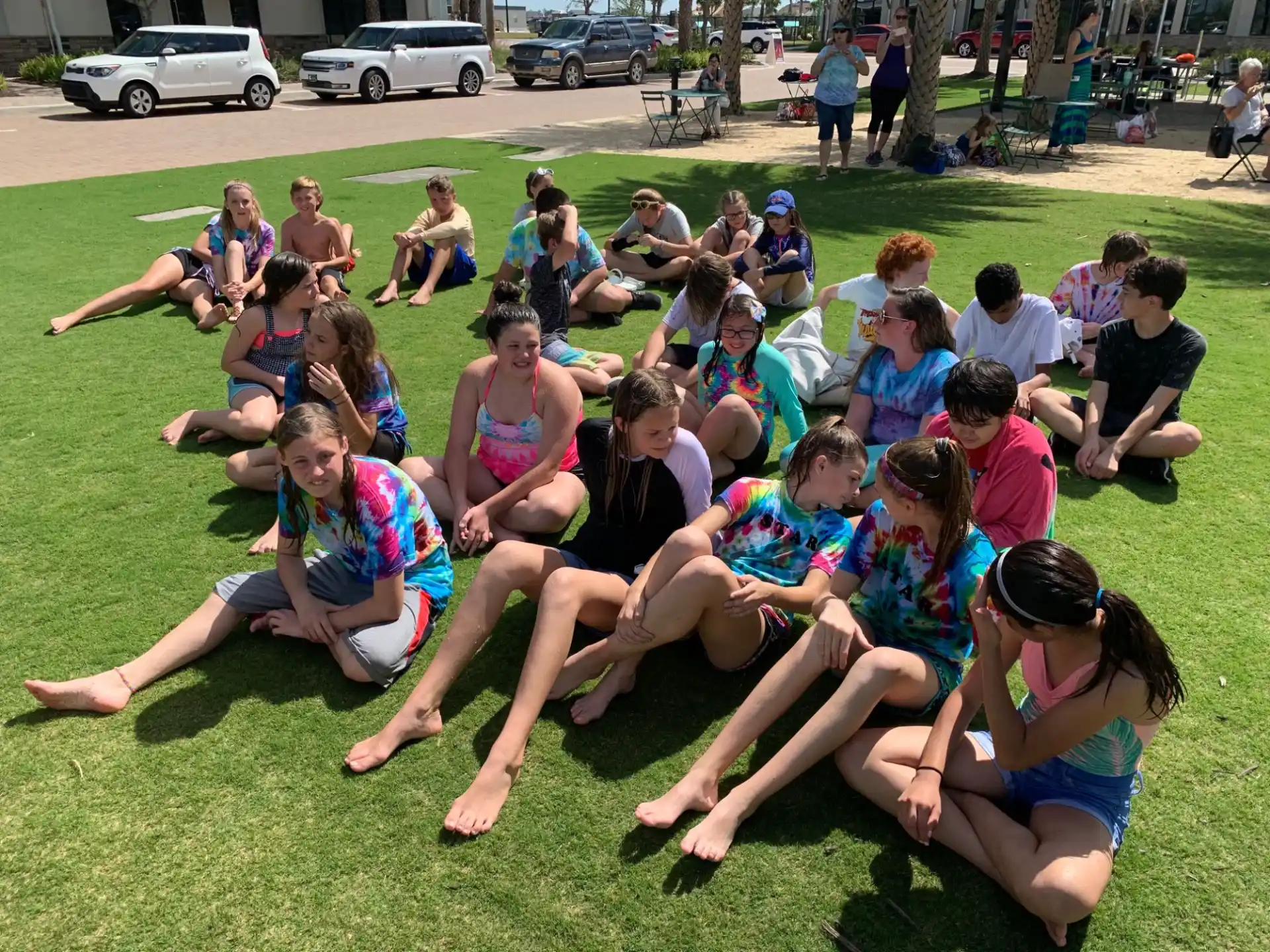 a group of people sitting on the grass
