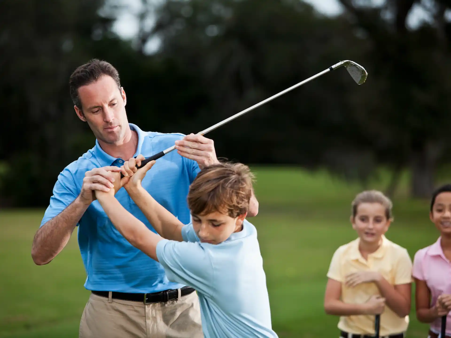 a man and a couple of kids playing with a bow and arrow