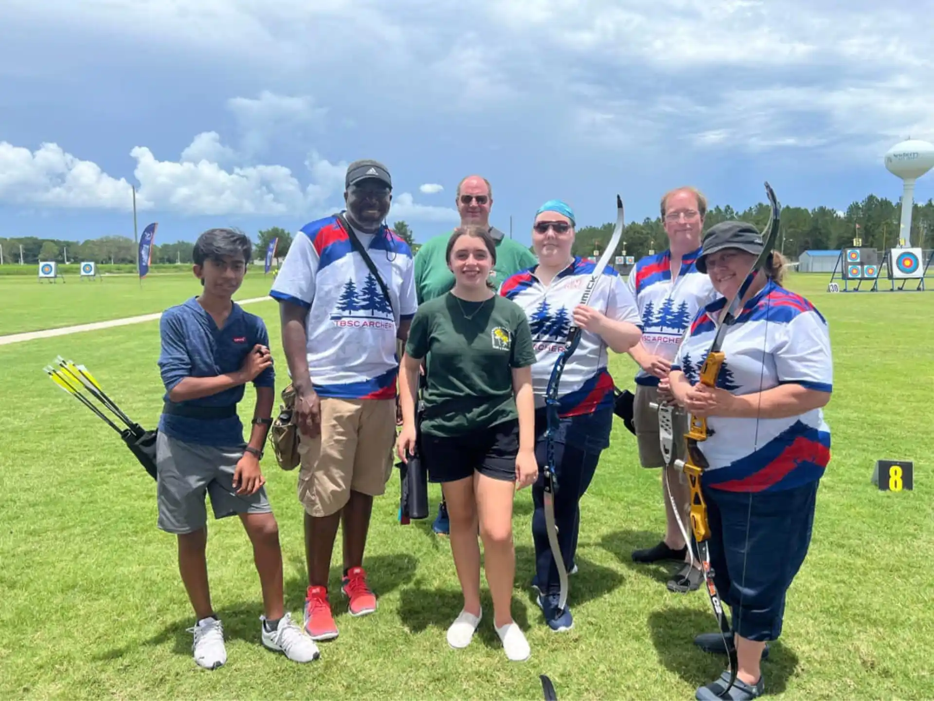 a group of people posing for a photo with bows and arrows