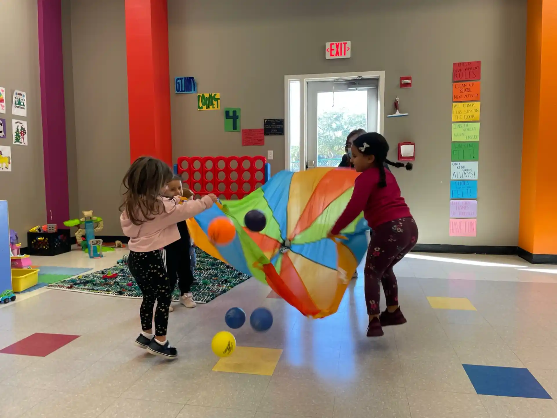 a person and a girl playing with a large ball in a gym