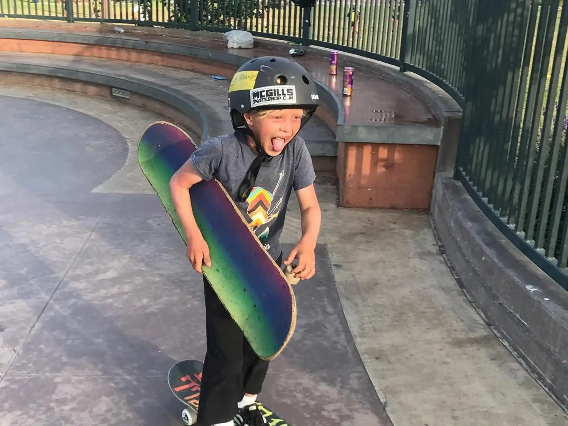 a boy wearing a helmet and holding a skateboard