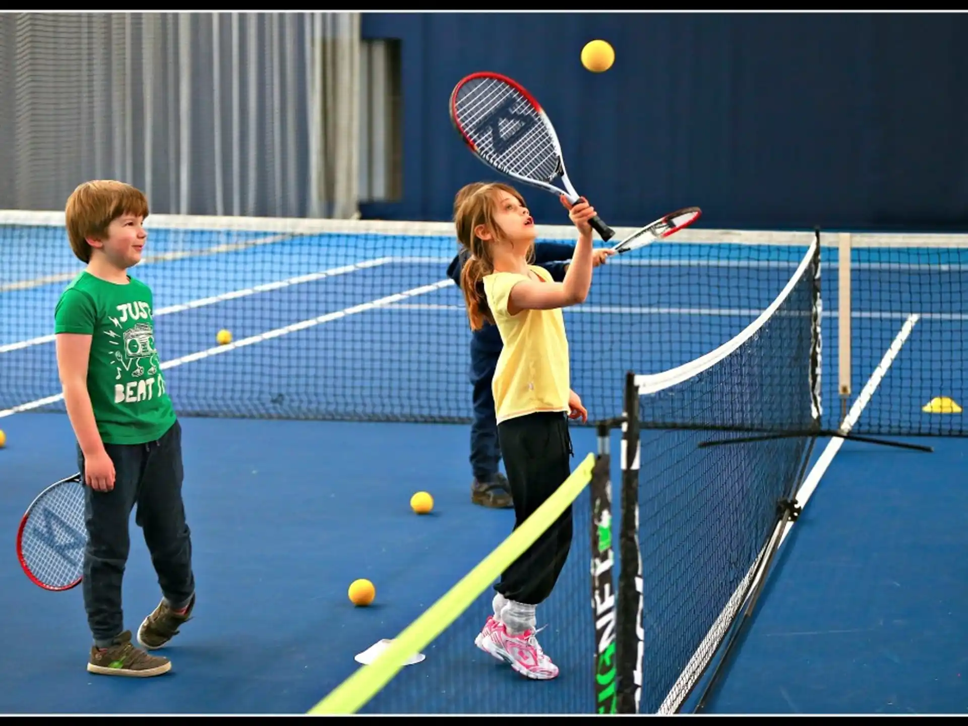 kids playing tennis on a court