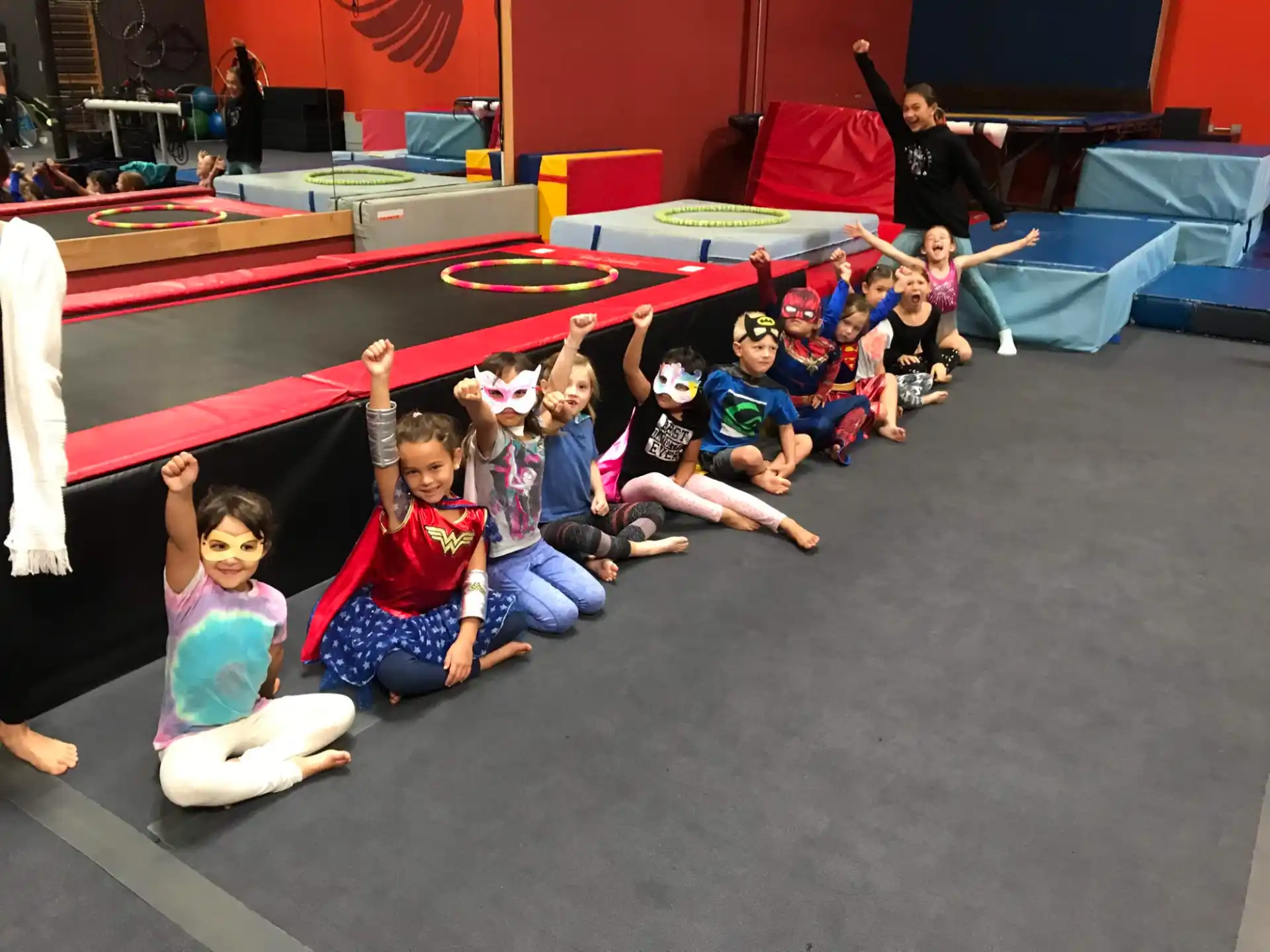 a group of children sitting on the floor posing for the camera