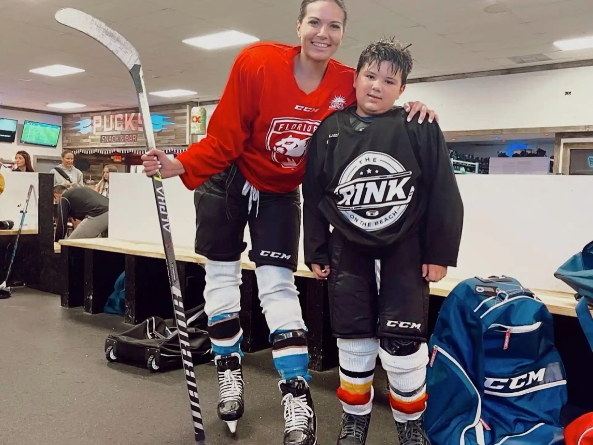 a man and a boy holding hockey sticks