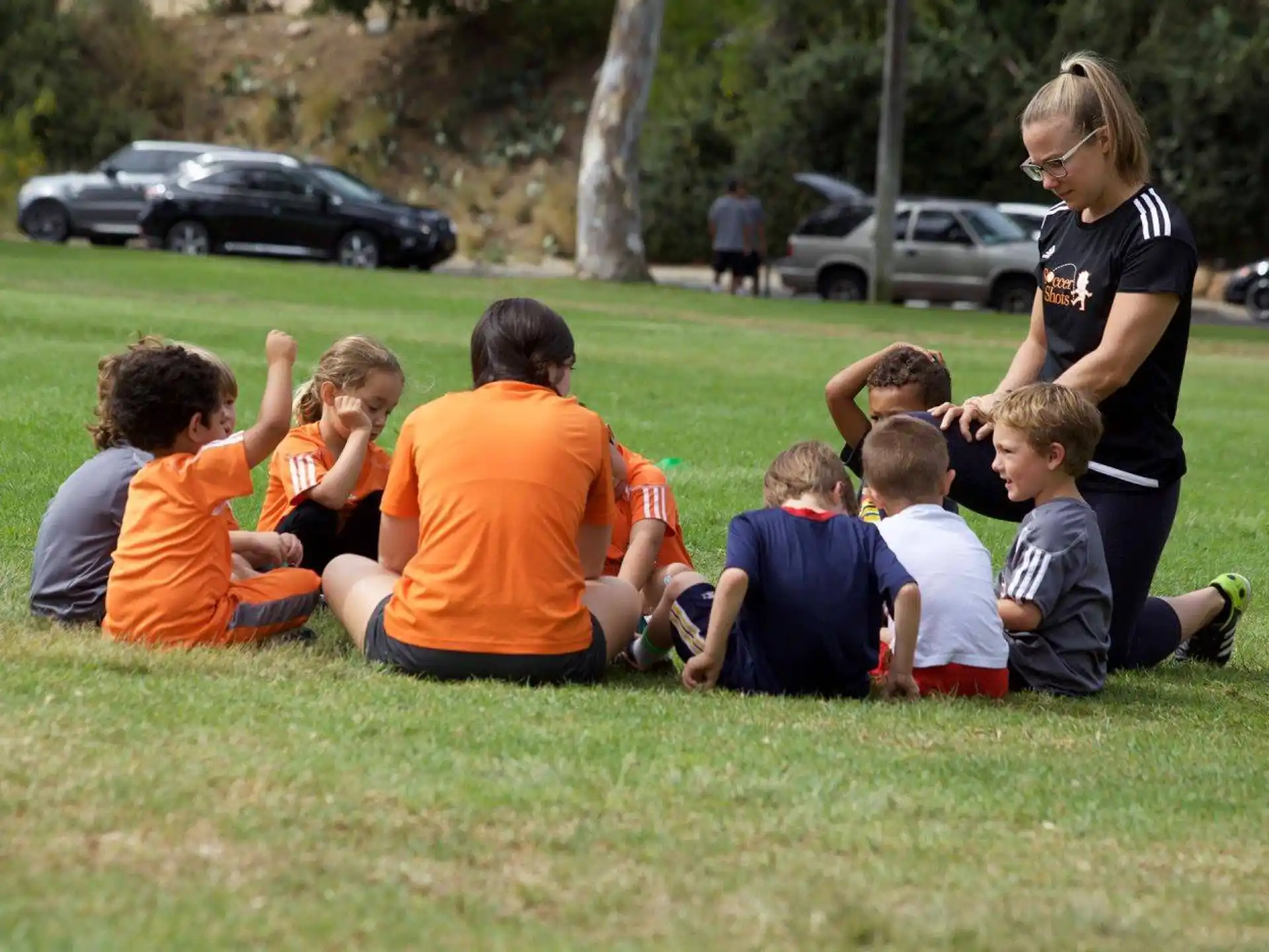 a group of kids sitting on the grass