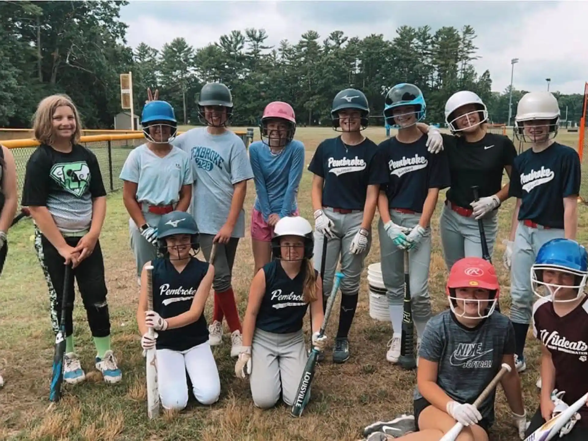 a group of people posing for a photo with helmets and bats