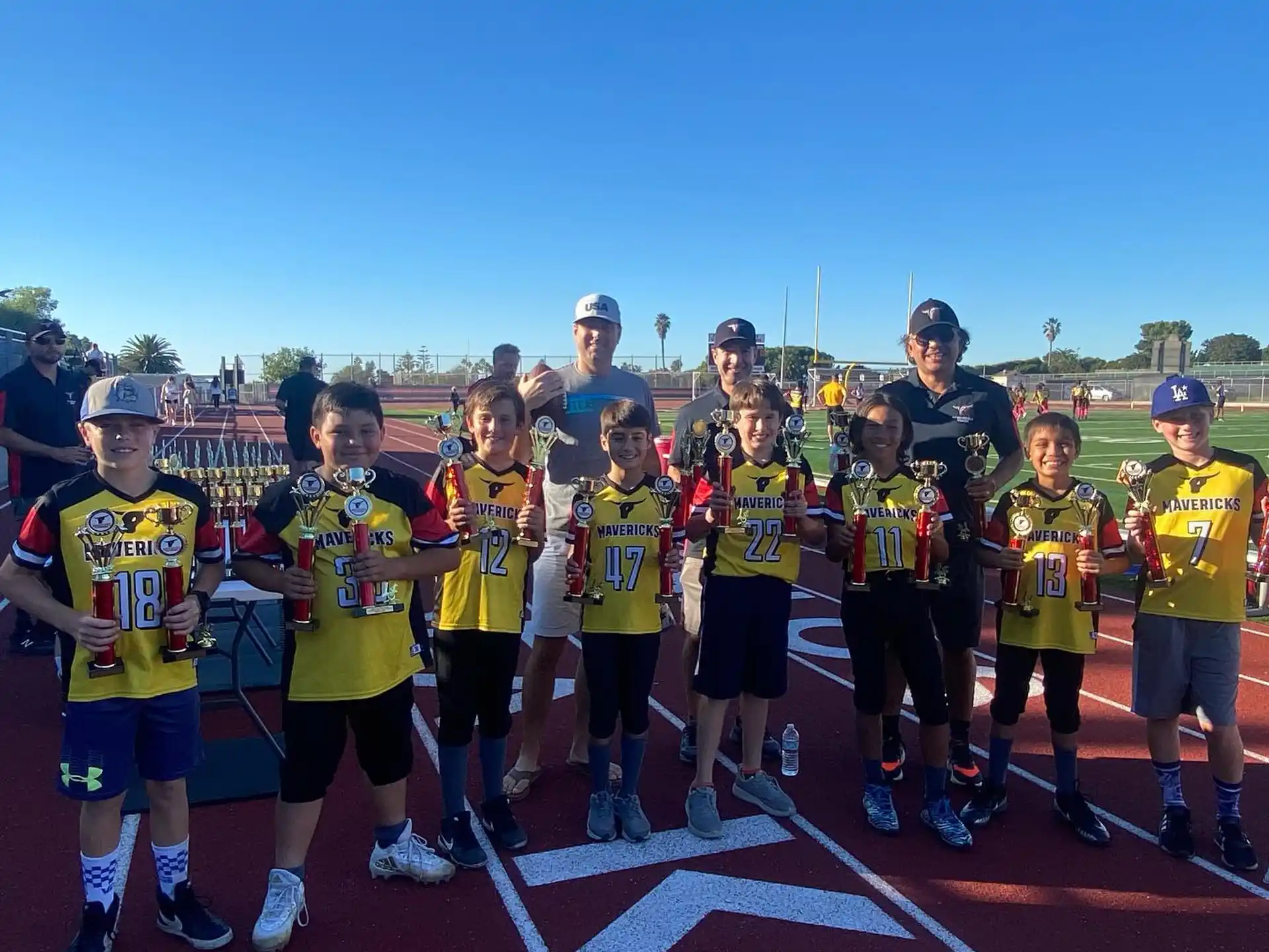 a group of people wearing numbers and standing on a track