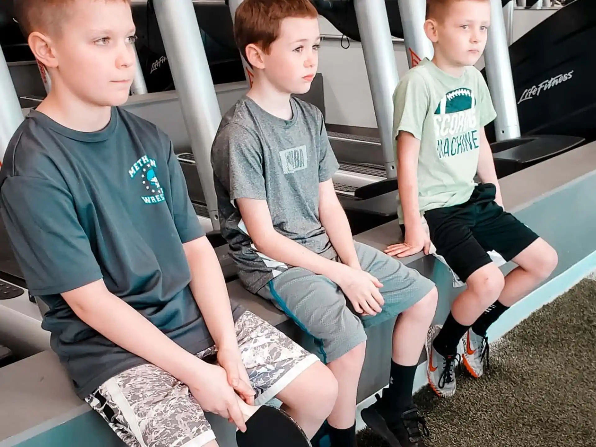 a group of boys sitting on a bench