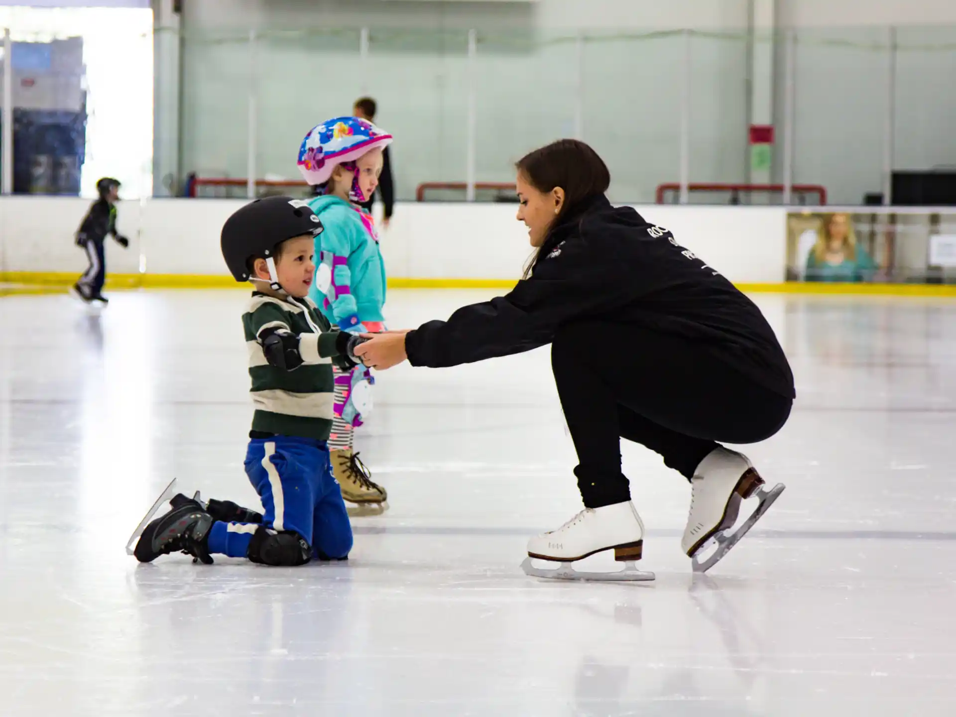 a man and two children on an ice rink