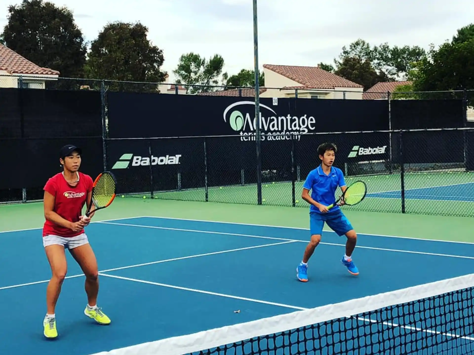 a couple of people play tennis