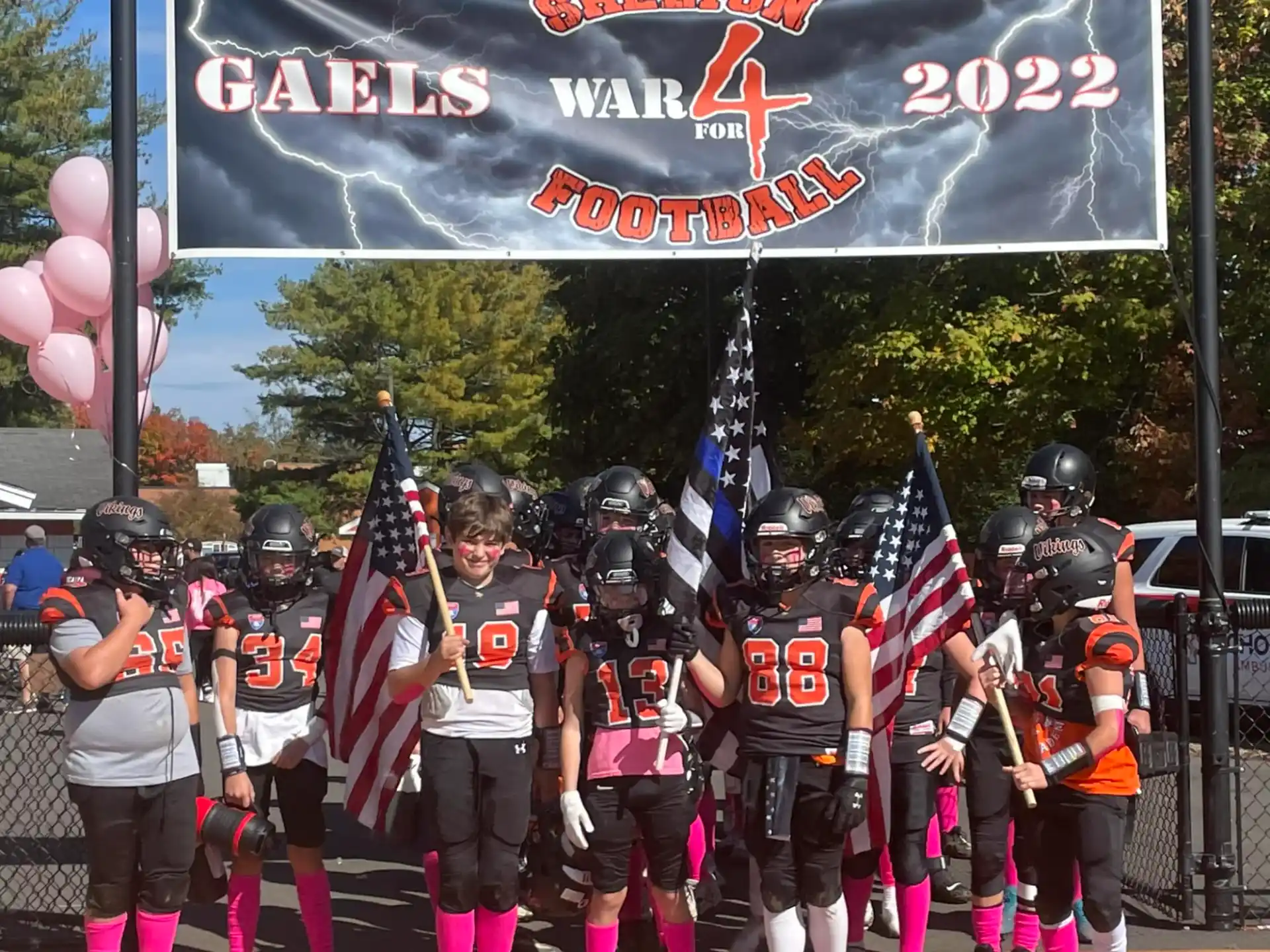 a group of people in uniform holding flags and a banner