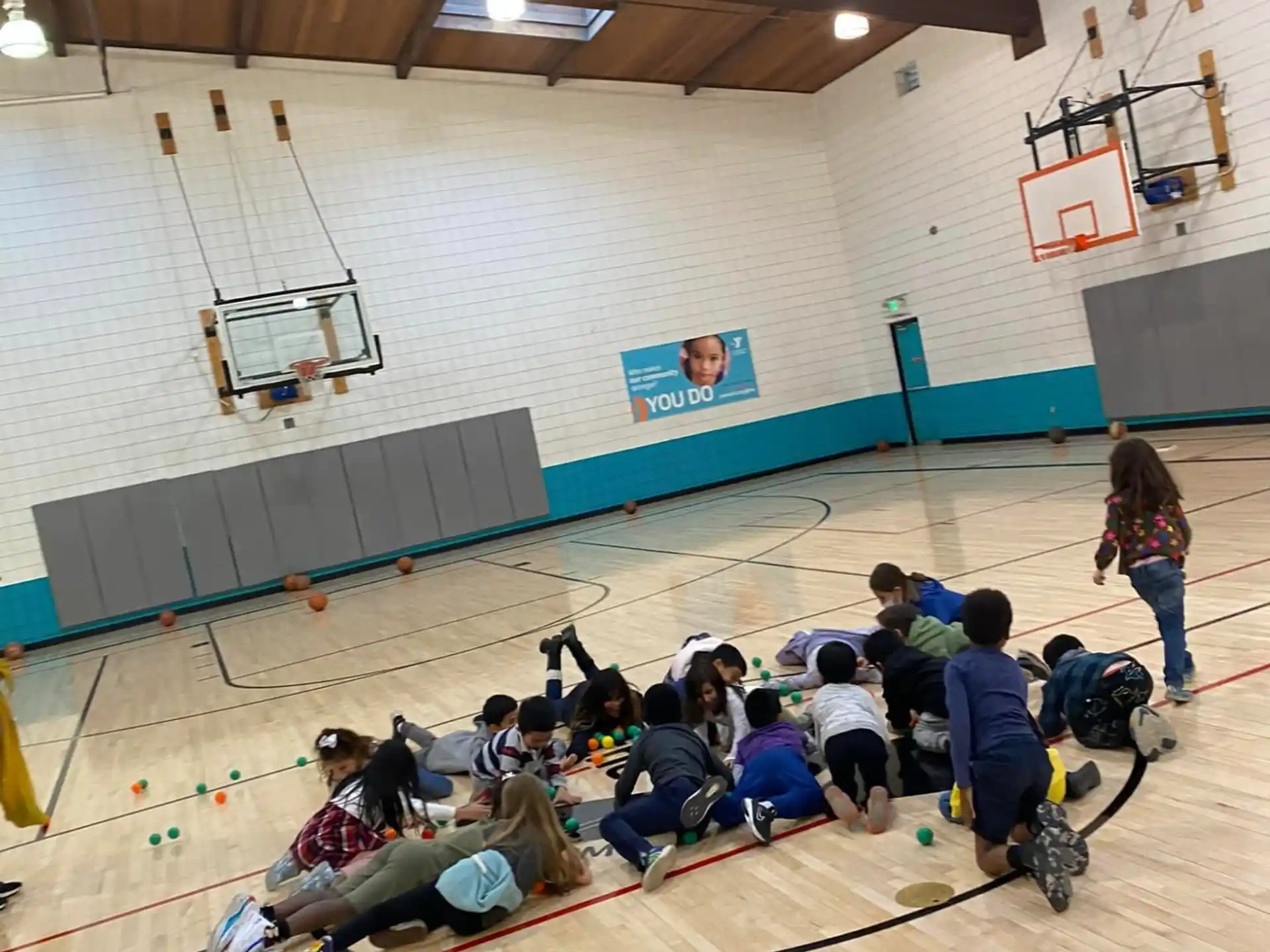 a group of people sitting on the floor in a gym