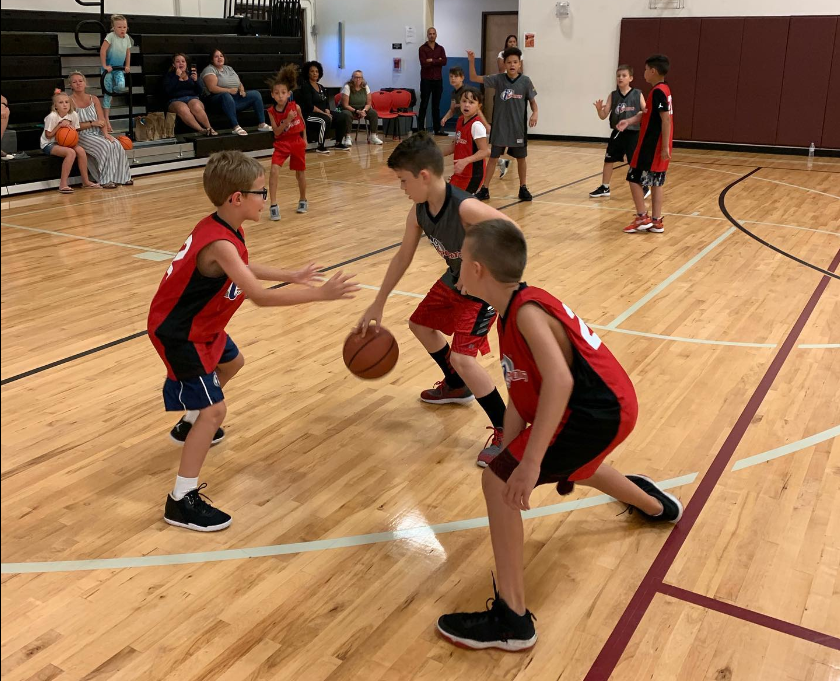 a group of kids playing basketball